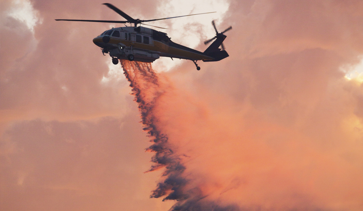 Helicopter dropping water on fire