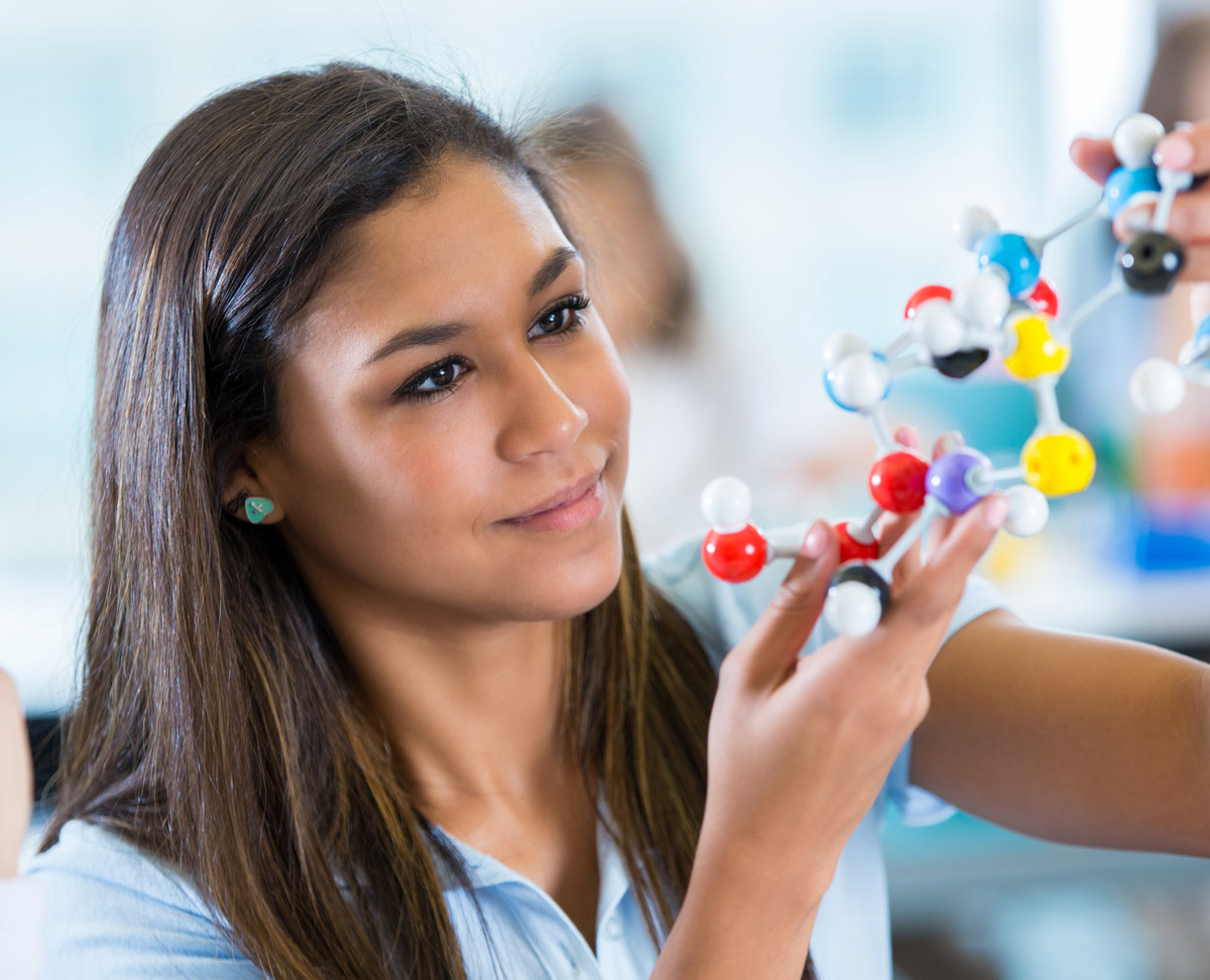 young female student looking at molecule diagram