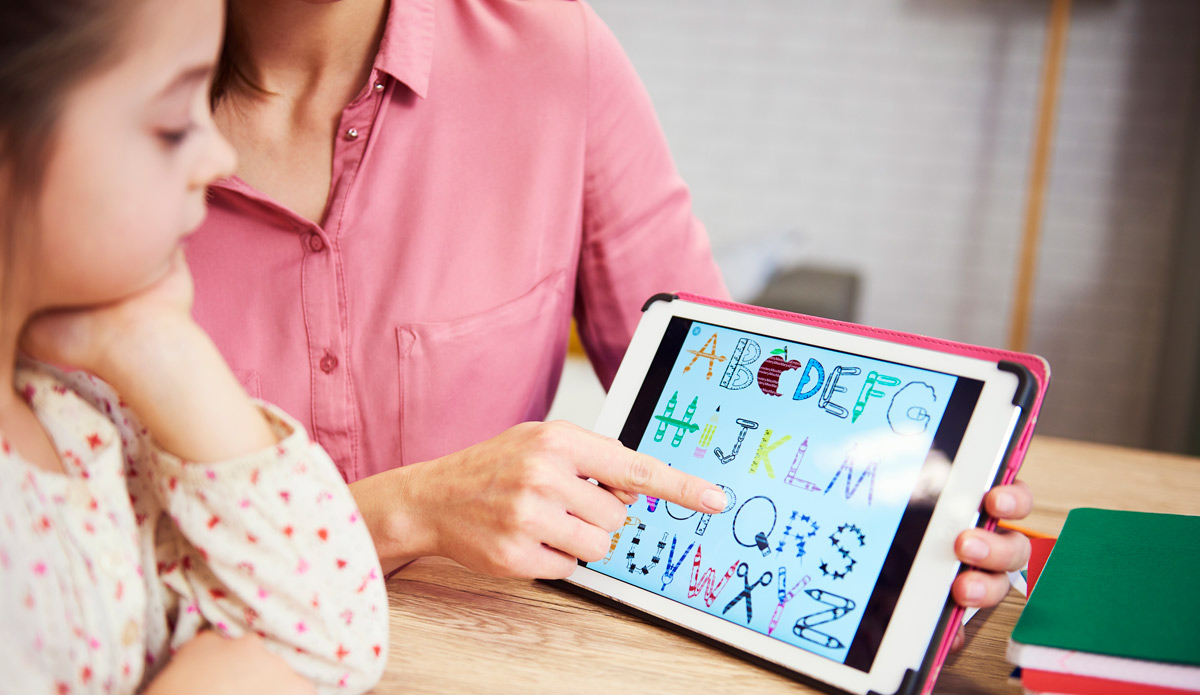 Woman teaching little girl using an ipad