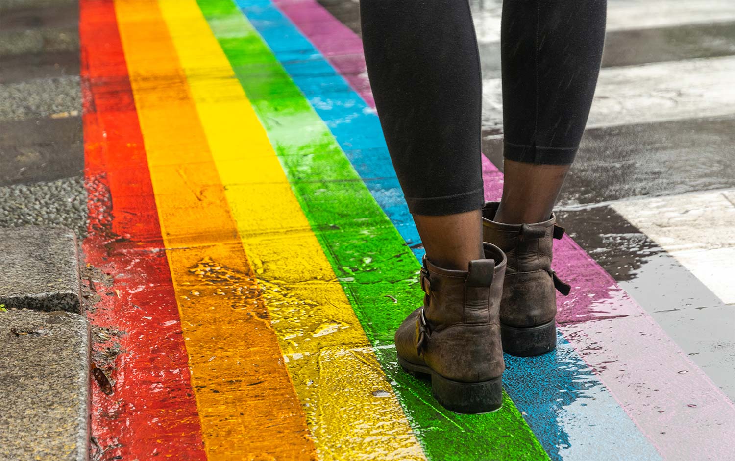 Woman standing on a pride symbol on the ground