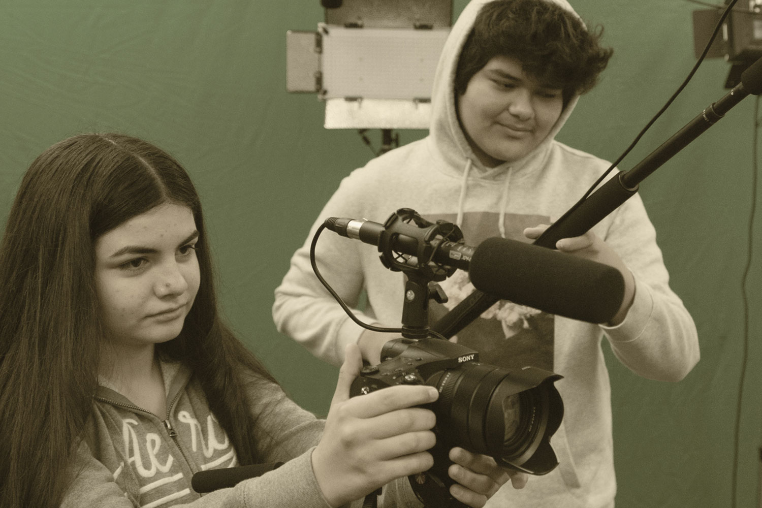 Two students operating film equipment