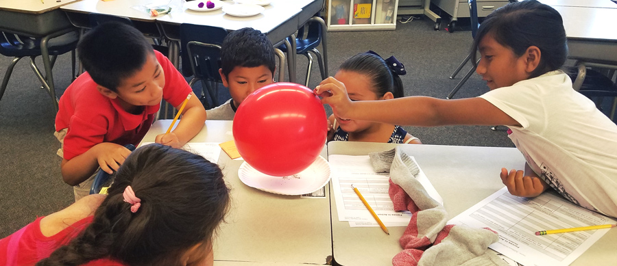 students using a balloon during a class experiment