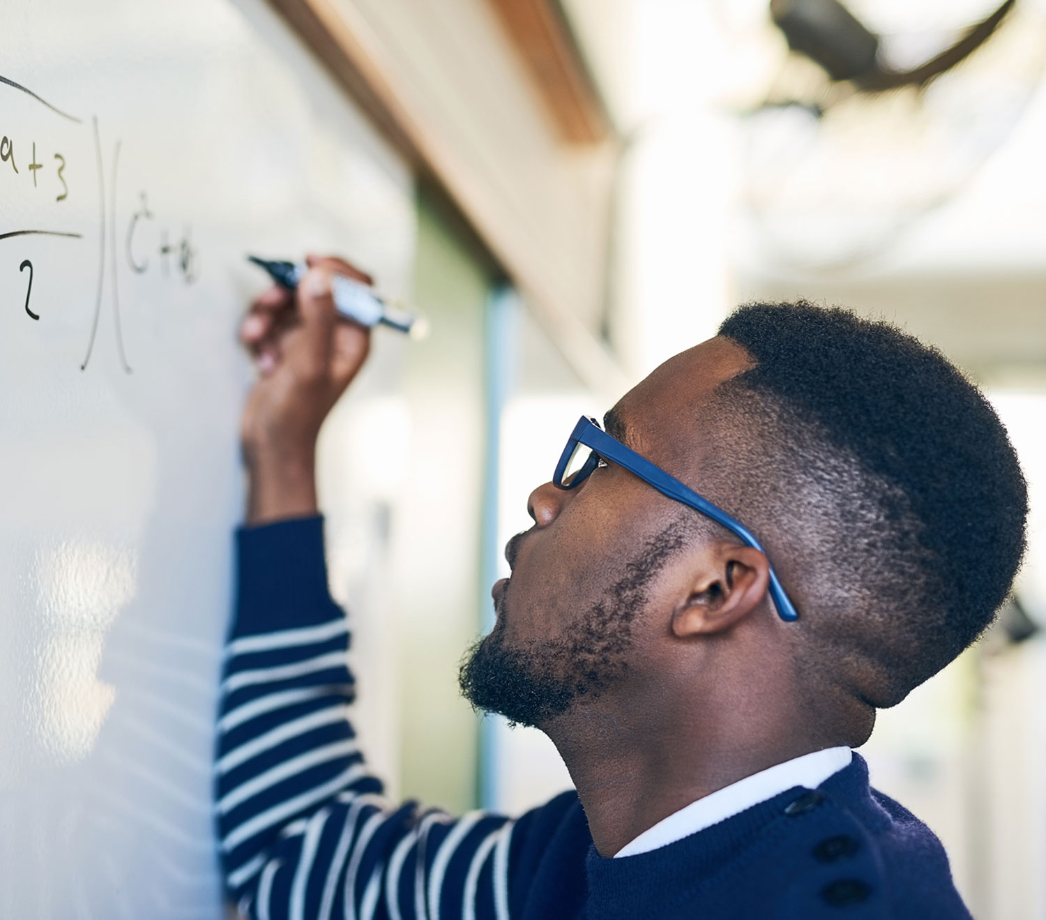 man doing math on a whiteboard