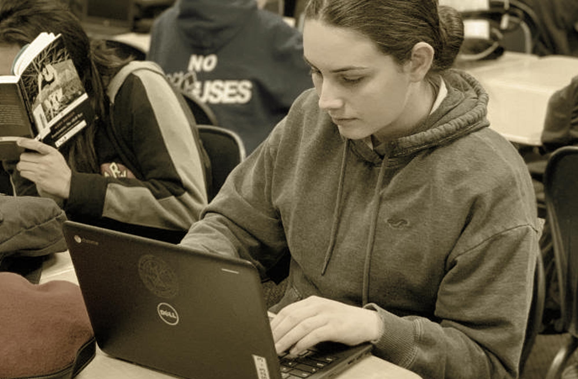 a young adult aged student studying on a laptop