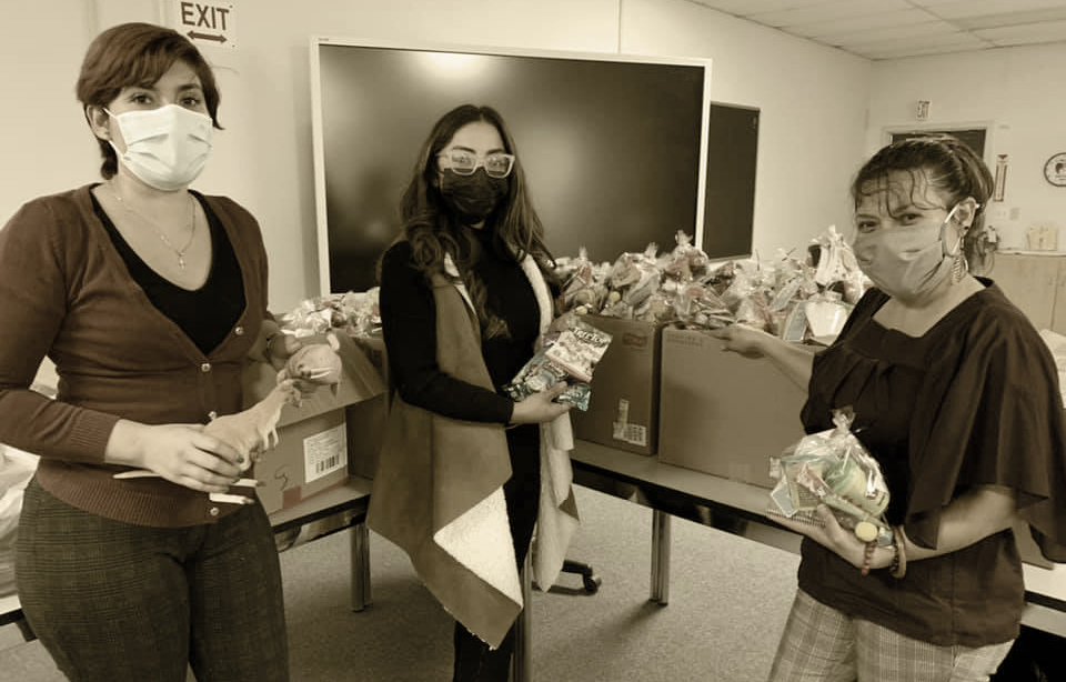 Three women holding care packages