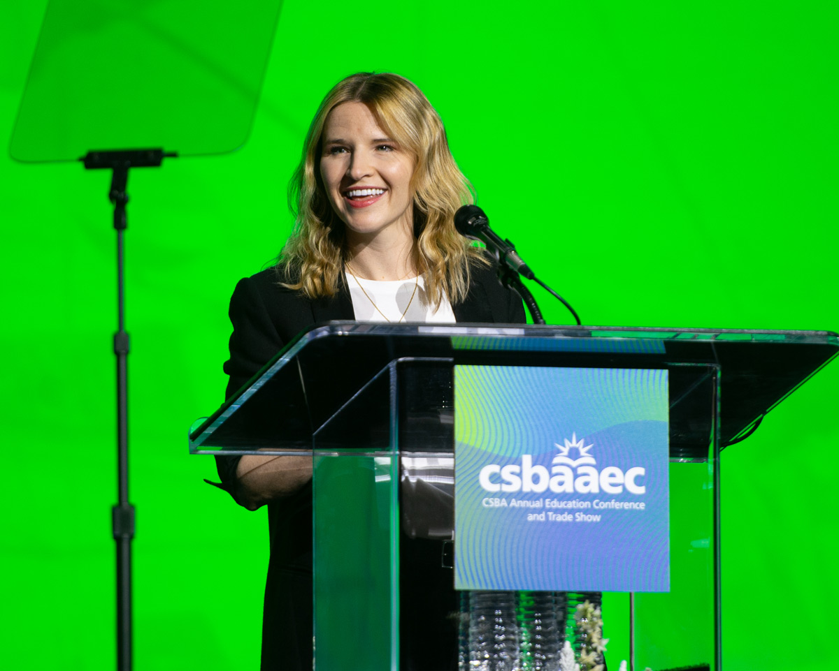 woman standing at podium in front of green screen