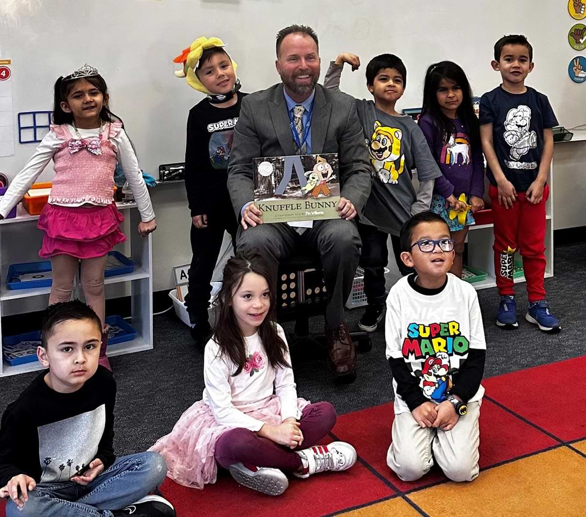 Brad Beach photographed with elementary aged children during a "Knuffle Bunny" story time