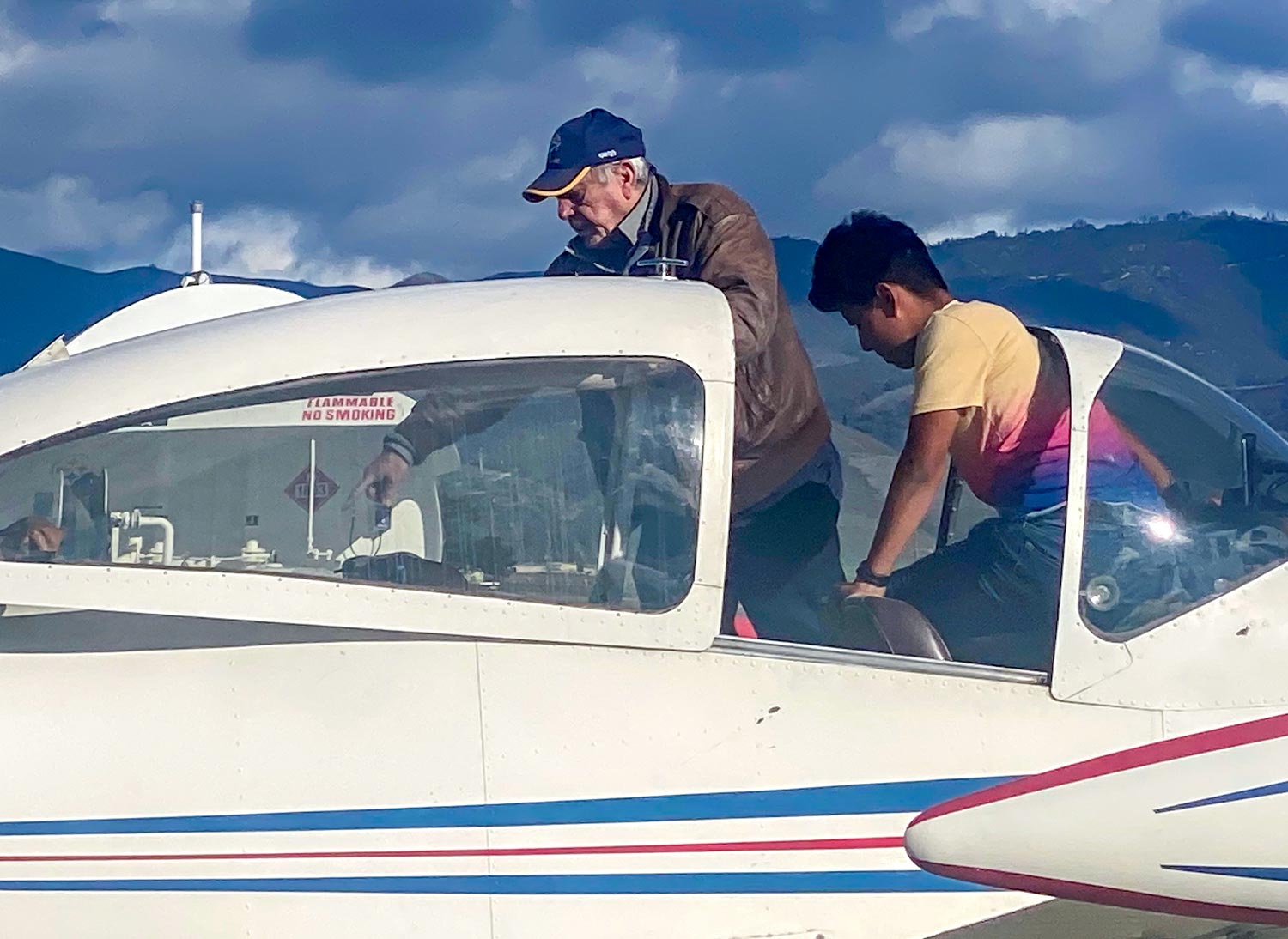 an older man and a young man evaluate the cabin inside a parked plane