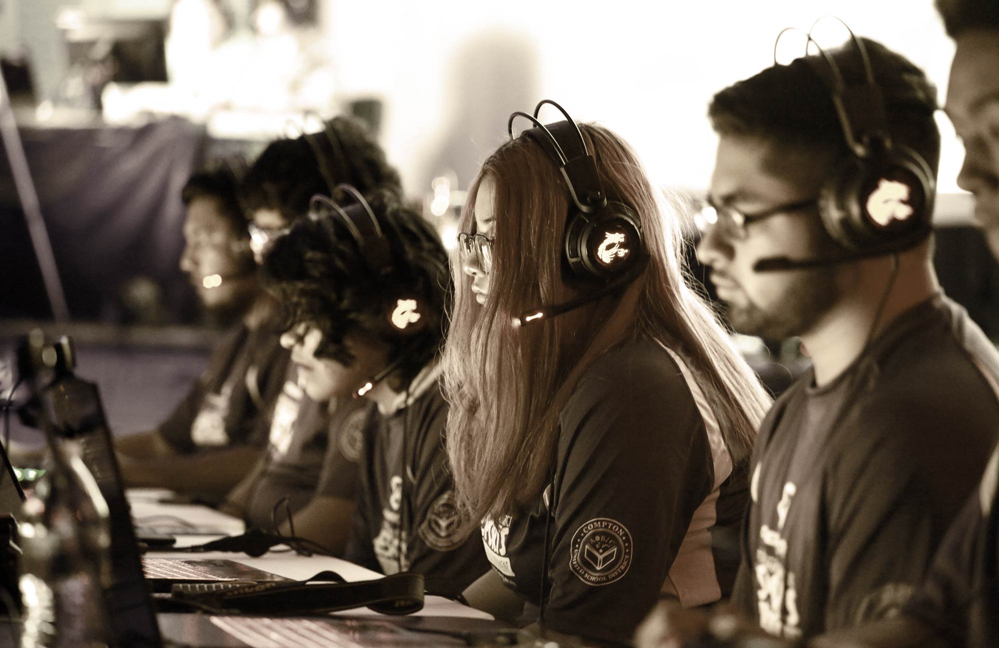 Close-up landscape photograph perspective of the Compton Unified Esports League (CUEL) participants in their gaming shirts and gaming headsets