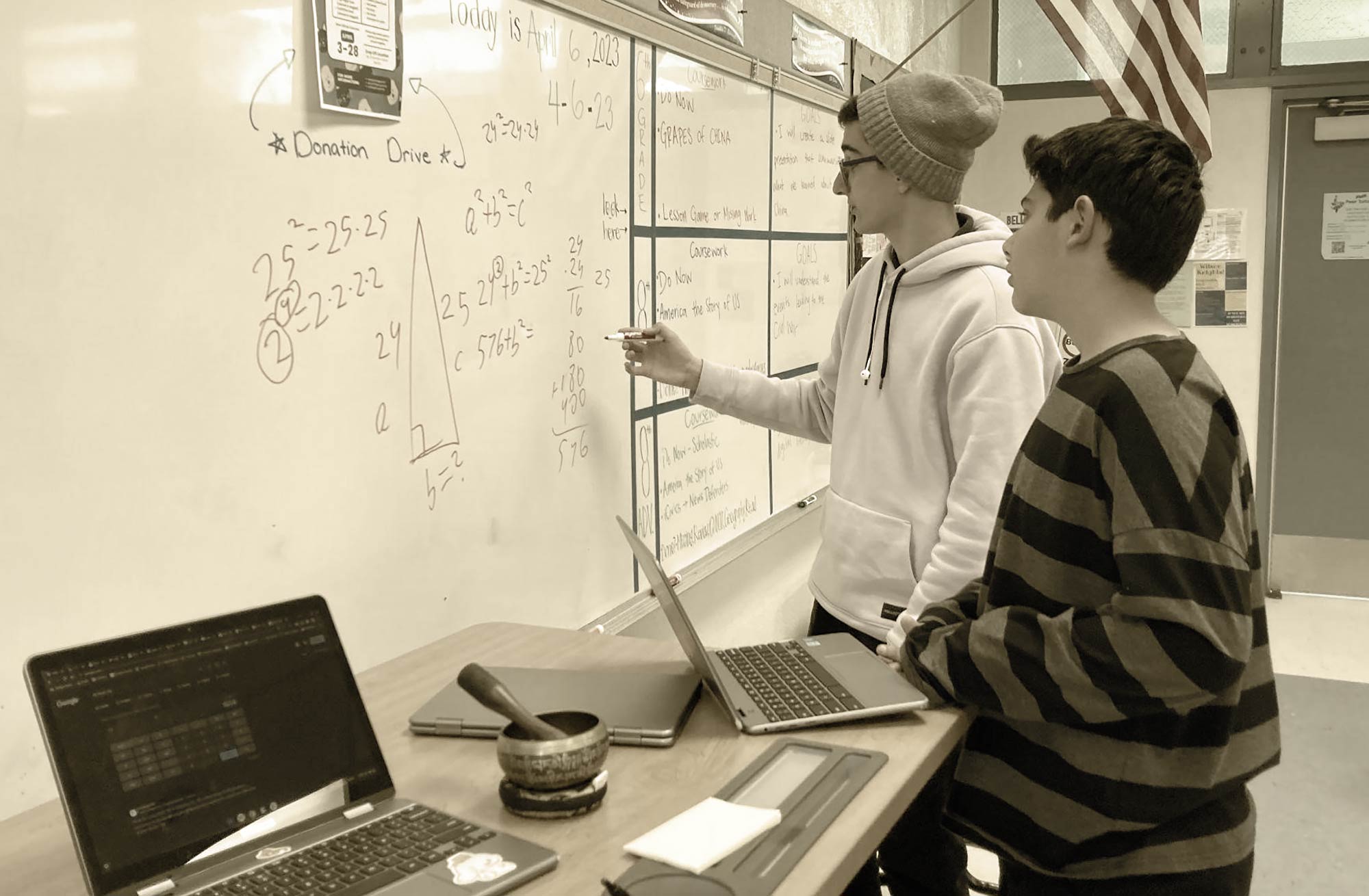 Close-up landscape photograph perspective of two students trying to learn, solve, and understand mathematics on a classroom white board