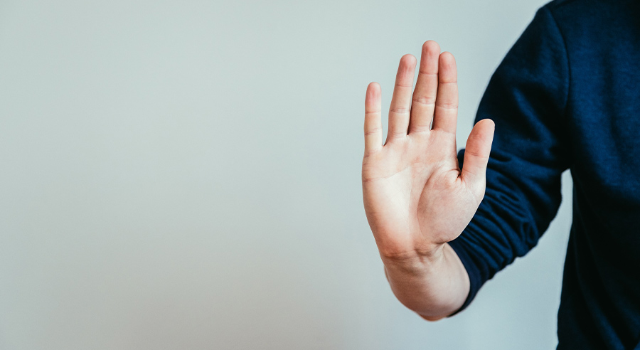 person in a blue shirt holding their palm out
