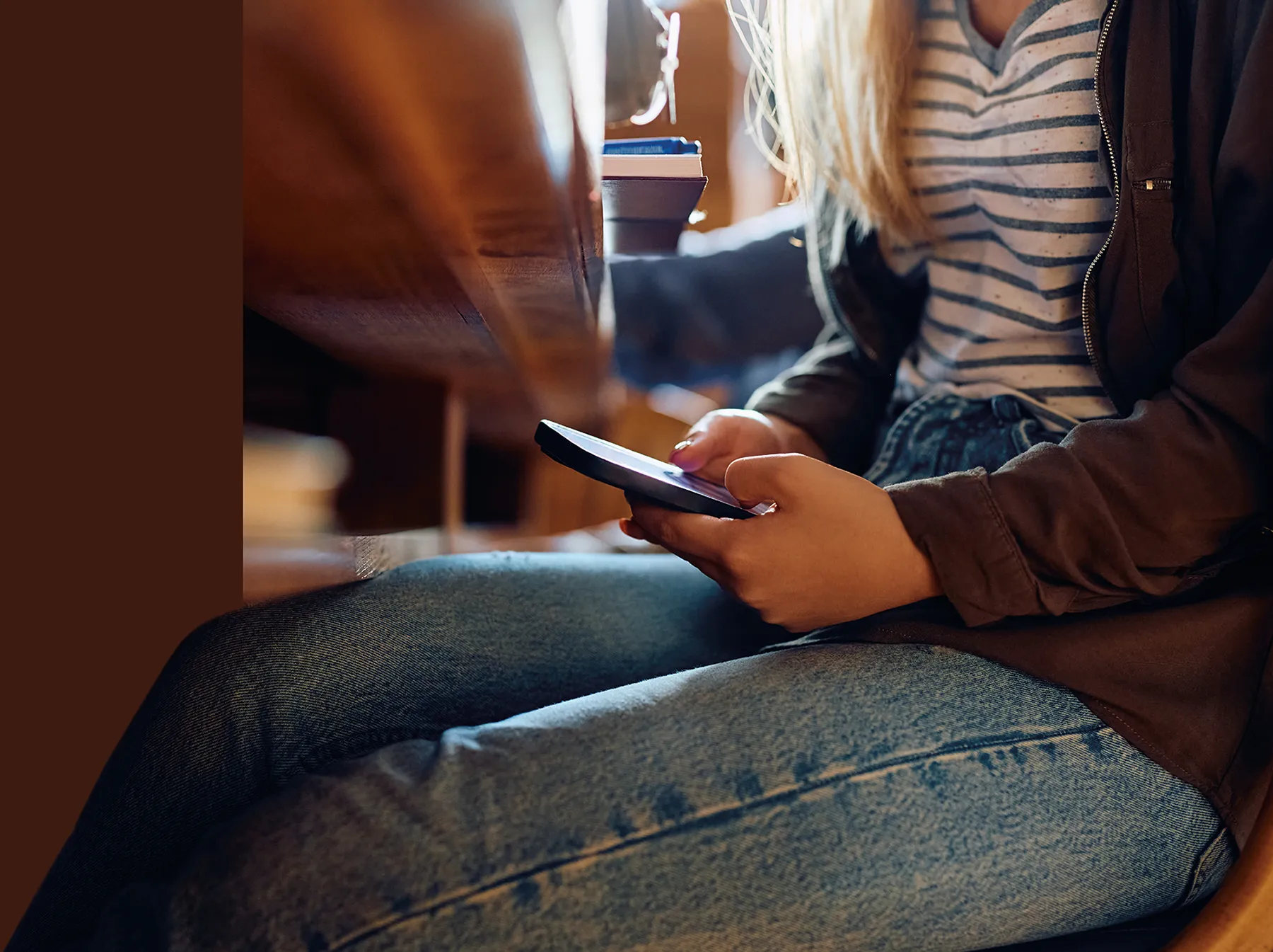 child sitting on at a table using their cell phone