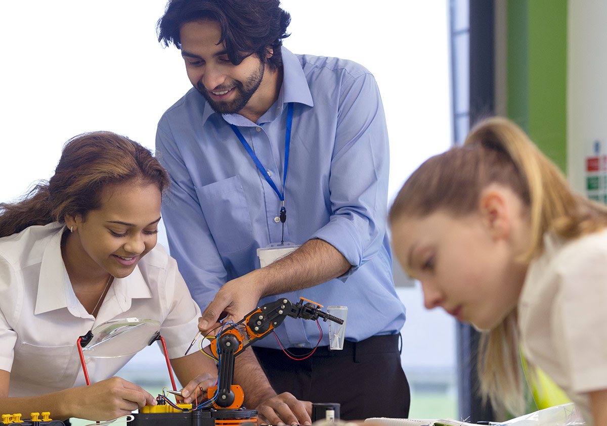 instructor teaching two students robotics