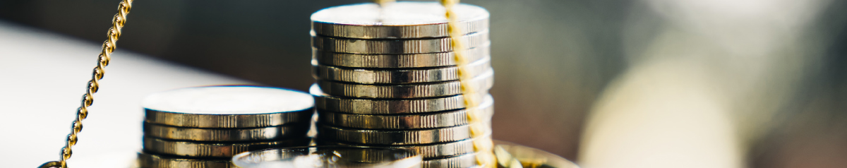 close cropped view of coin stacks in a scale pan