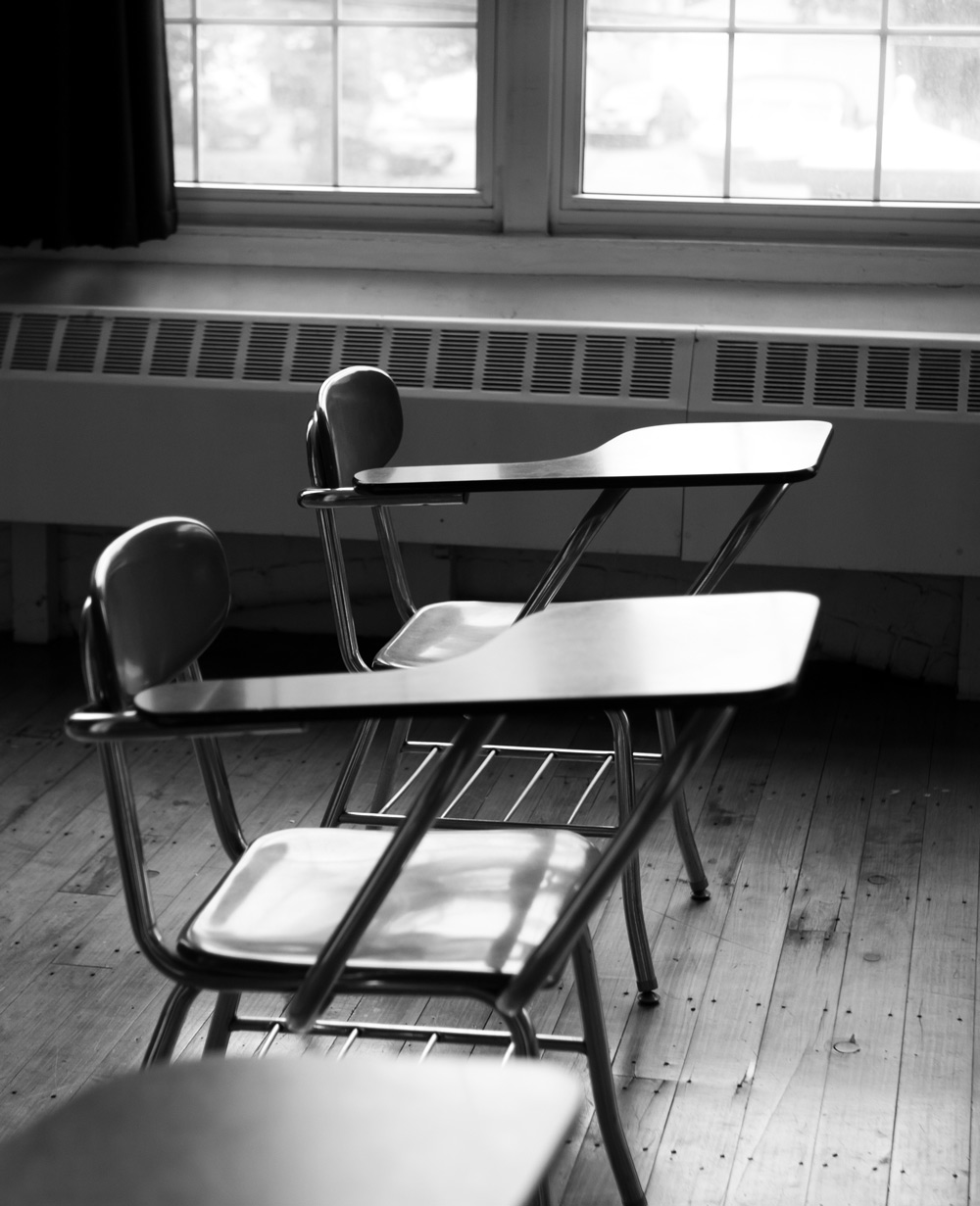 black and white photo of empty desks 