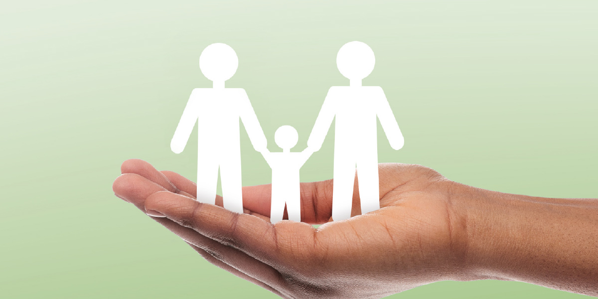 Mint green color digital background containing a person's hand holding white cut-out artistic people figure shapes that resemble two parents holding their kid's hands
