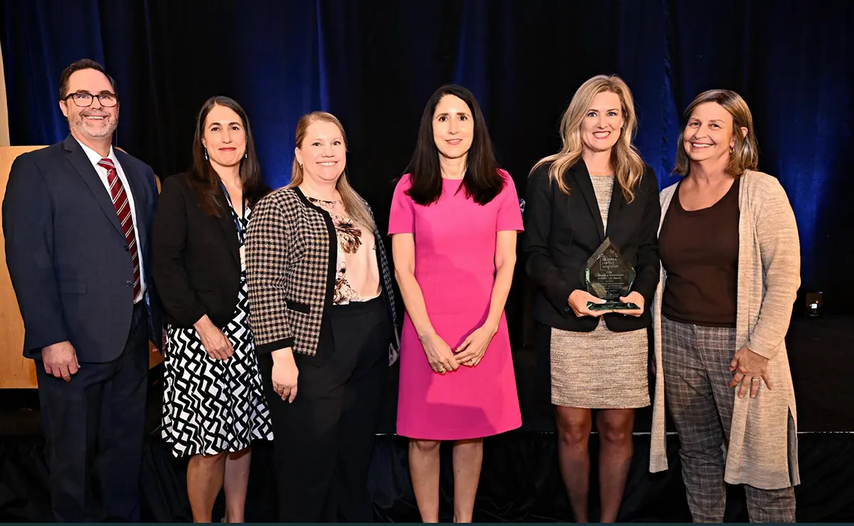 six adults made of ELA members and representatives from Fagen Friedman & Fulfrost LLP take a group photo at an awards ceremony as one of the pictured women holds a glass trophy