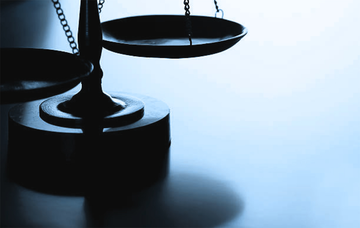 Close-up dark overlay layered shadow cropped portrait orientation photograph of a balanced even scales of justice object on a light to medium sky baby blue background