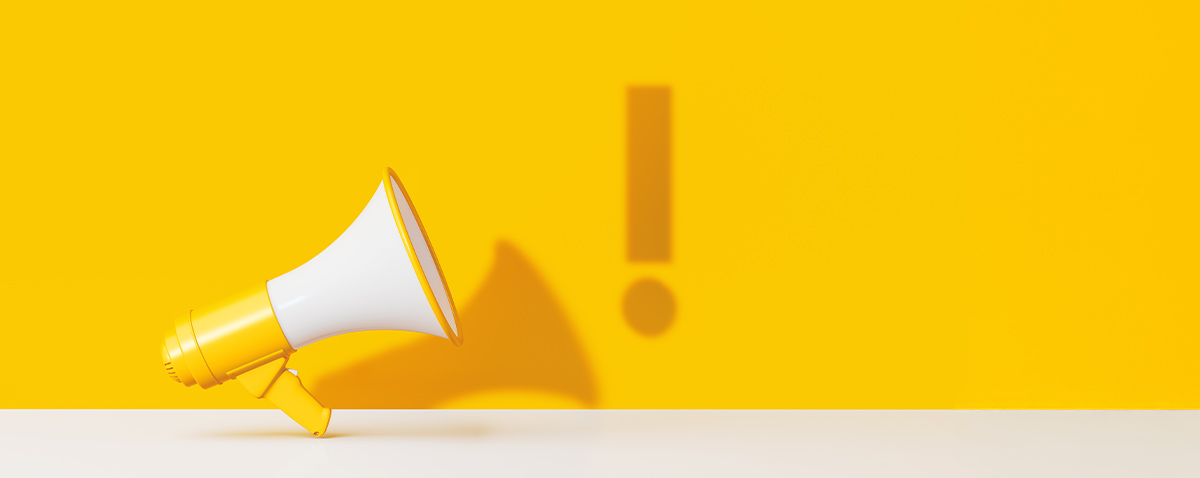 a bright yellow and white megaphone against a bright yellow background, an exclamation point shadow floats beside the megaphone's shadow