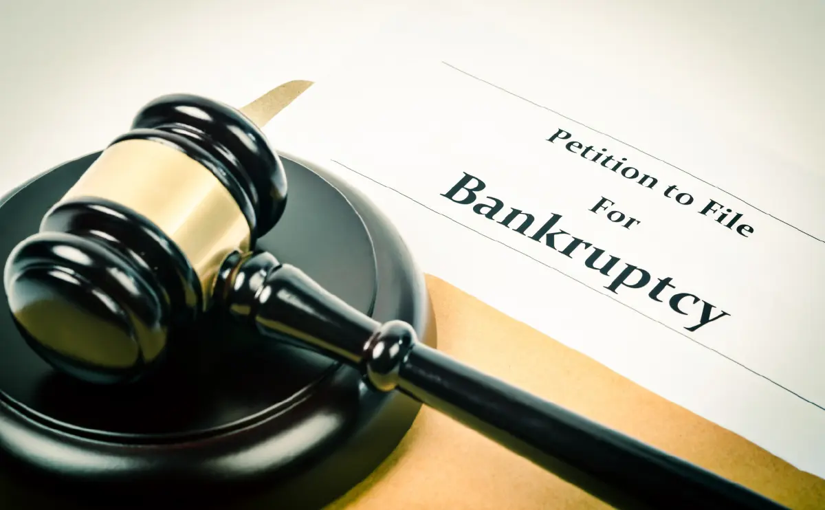 Digital image of a black gavel resting on a white document that reads the following: Petition to File For Bankruptcy