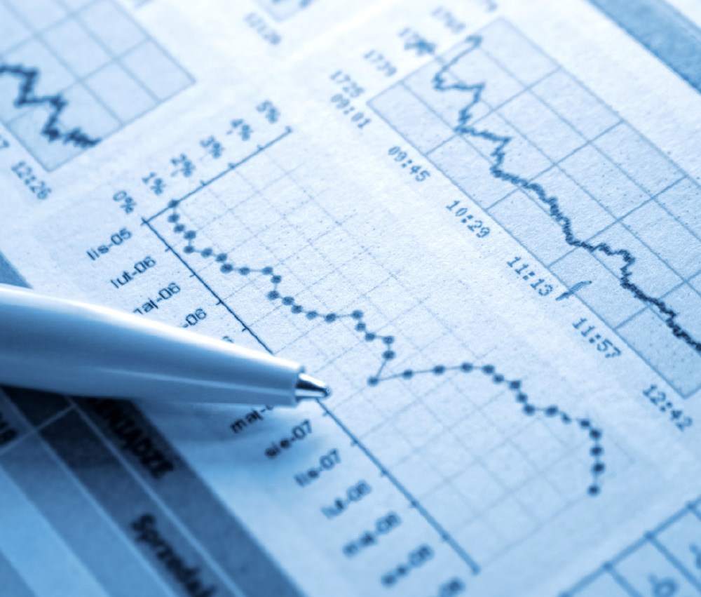 Close-up, cool-toned image of a pen tip resting on a printed financial chart showing a significant downward trend line.