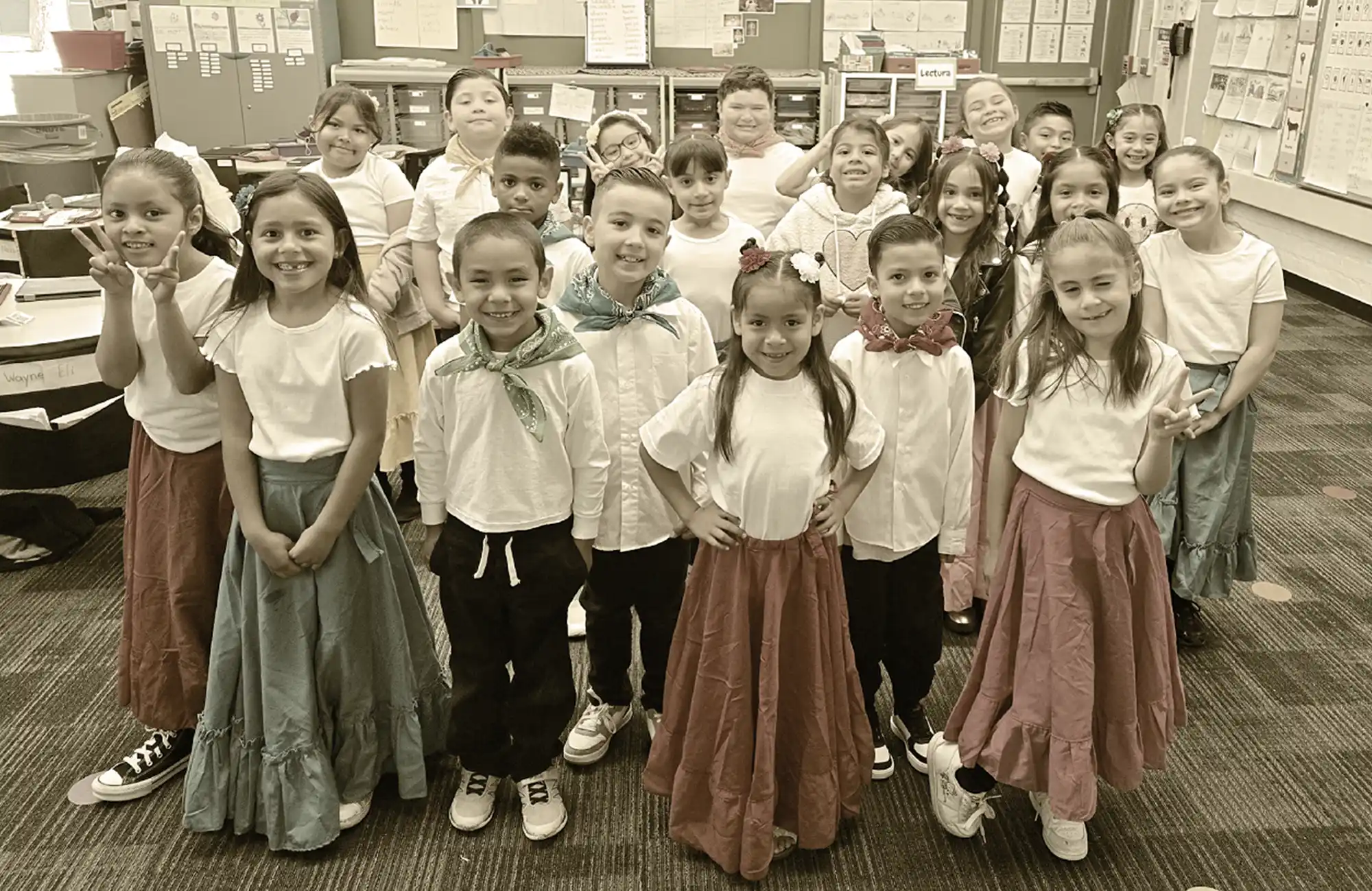 Students in white shirts and long skirts posing for a class picture.