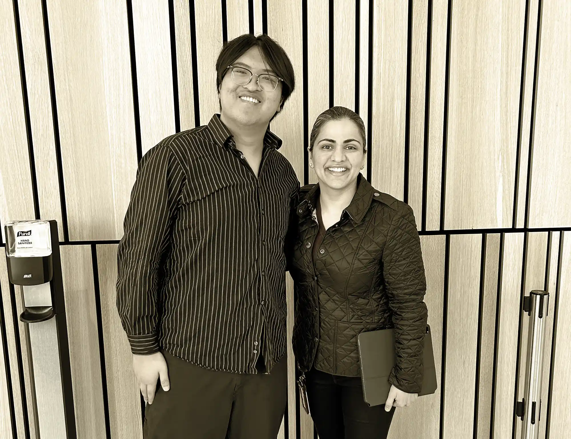 Two people posing for a picture in a public building.