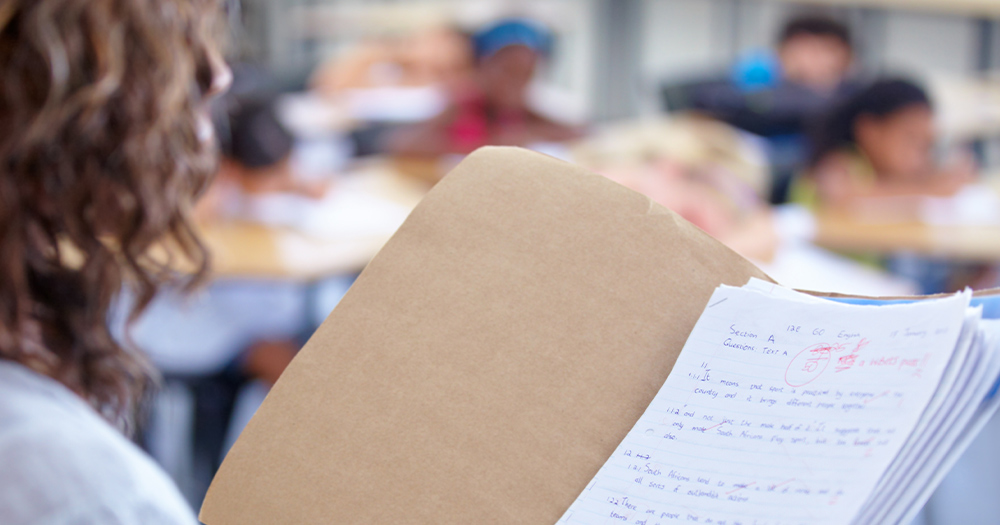 woman looking at folder of graded papers