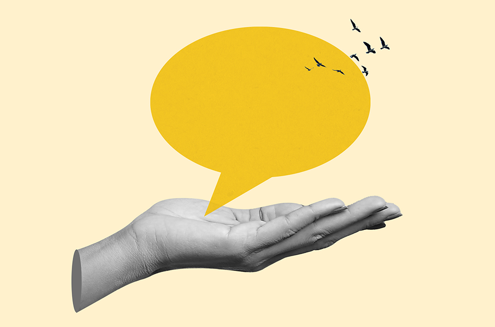 A conceptual illustration featuring a grayscale open palm holding a large yellow speech bubble, with small birds flying away from the top edge.