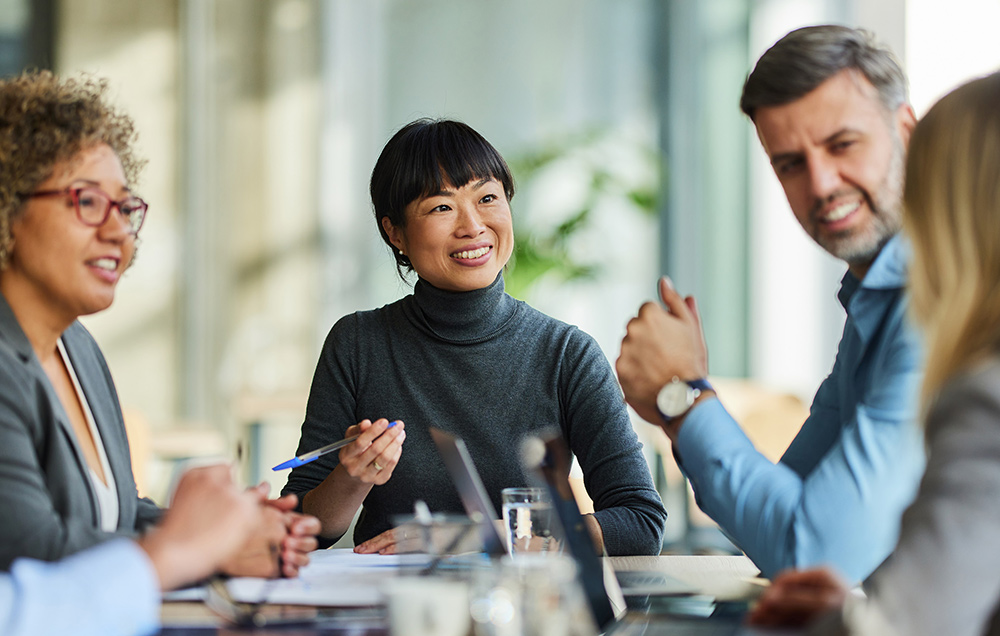 Diverse group of professionals sitting around a table having a collaborative meeting.